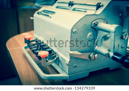 Vintage mechanical adding machine on table