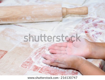 Baking Christmas cookies, child hands cuts dough