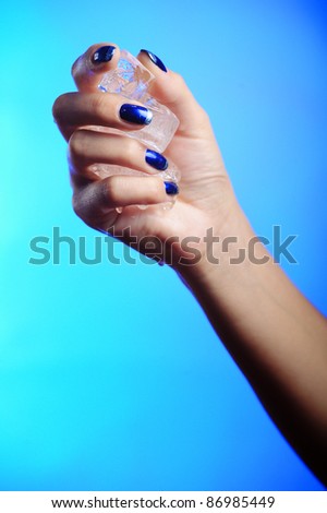 hands with woman\'s blue french nails manicure and with ice cubes