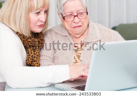 Learning Internet. Daughter teaches her elderly mother using a computer