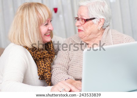 Learning Internet. Grandmother watching her daughter while teaches her elderly mother using a computer