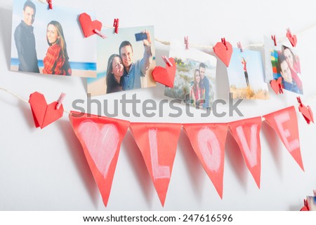 Homemade love decoration. Wall with pictures and garland hanging on clothesline