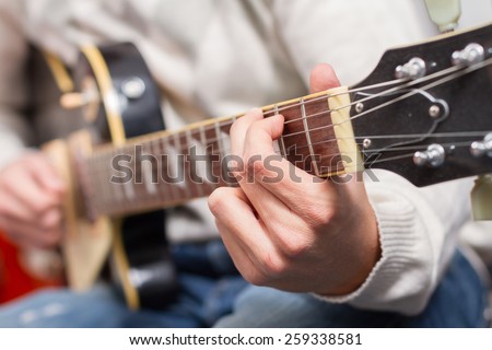 Closeup hand of man playing electric guitar. Selective focus on hand