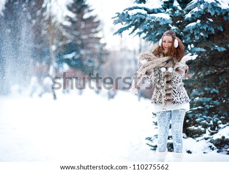 winter portrait of a beautiful girl in snowy forest