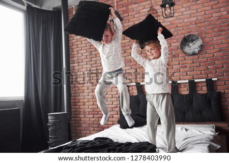 A Two Boys Is Fighting By Pillows In Bedroom Images And