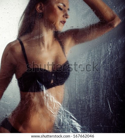 Beautiful woman behind the shower curtain relaxing