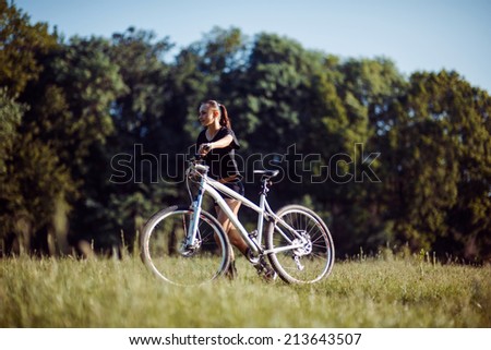 Portrait of healthy fit and sporty, confident and successful mature woman cycling on mountain bike, isolated with blue sky as background and copy space.