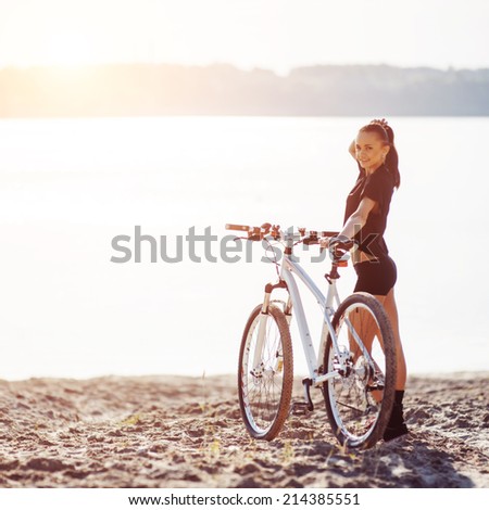 woman on a bicycle in a park area near the water