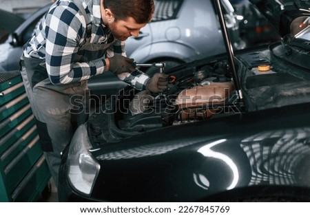 Similar – Image, Stock Photo Busy male mechanic repairing motorcycle seat in workshop