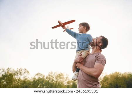 Similar – Image, Stock Photo Father and son playing on the field at the day time. People having fun outdoors. They jumping on inflatable balls on the lawn. Concept of friendly family.