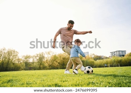 Image, Stock Photo Father and son playing on the field at the day time. People having fun outdoors. They jumping on inflatable balls on the lawn. Concept of friendly family.