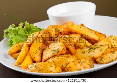 Fried potato wedges with white sauce and lettuce