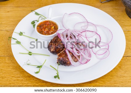 Kebab with sauce and pickled onions