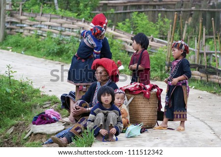 SAPA, VIETNAM - JULY 8: Red Dzao family in Ta Phin Village on July 8, 2009 in Sapa, Vietnam. Red Dzao are famous for their elaborate dress and normally tie up their long hair into a large red turban.