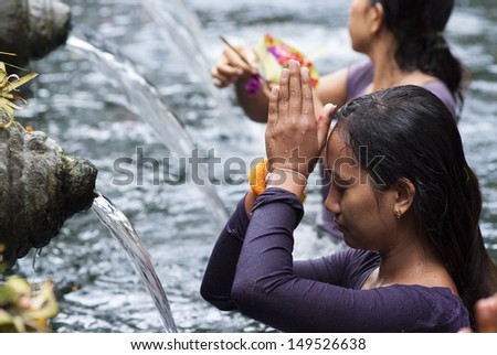 BALI, INDONESIA -  MAY 6: Worshippers make an offering at the Tirta Empul Temple on May 6, 2013 in Bali, Indonesia. They believe that water from the spring is holy and has the healing power.