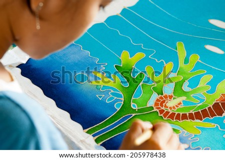 BANGKOK, THAILAND - APR 01: A woman using a Batik technique on fabric on Apr 01, 2007 in Bangkok, Thailand. Batik is a method of producing designs on fabric by using wax.