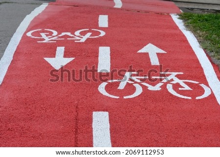 Similar – Foto Bild Radweg mit roter Fahrbahnmarkierung bei winterlichen Straßenverhältnissen.