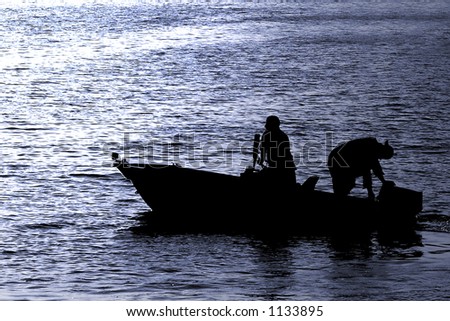 Silhouettes of boaters headed out late in the day