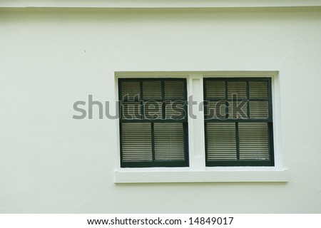 Close up of a window on the side of a white stucco building.