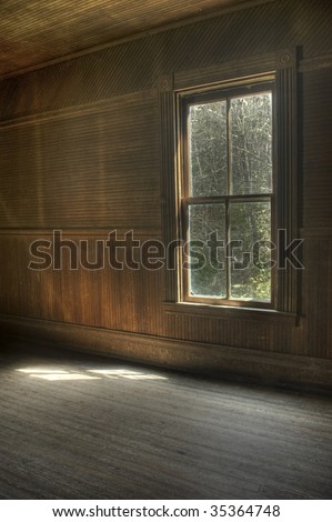 The interior of an abandoned vintage house with  natural light on floor from single window.