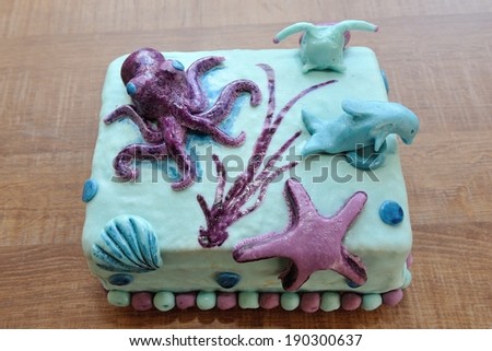 Beautiful birthday cake in submarine decoration with dolphin, octopus, snail and underwater star