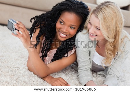 Two women are lying on the floor and are posing for a picture