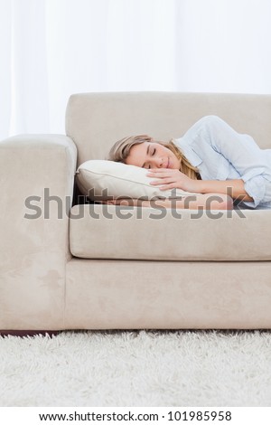 A woman is sleeping on a pillow on a couch
