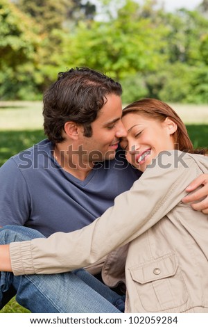 Man with his arm around his friend who is resting her head on his shoulders with her eyes closed