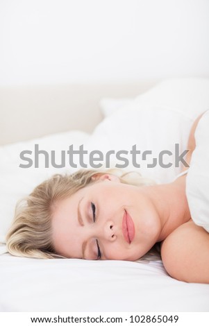 Woman sleeping with a smile in her bed