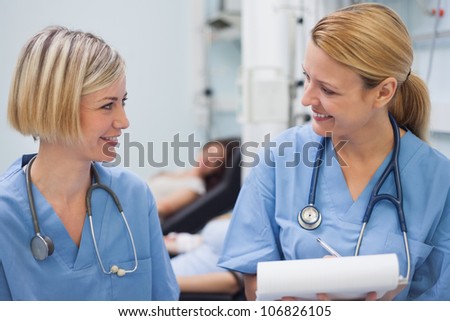 Smiling nurses talking in hospital ward