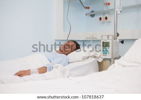 Asleep patient on a medical bed in hospital ward