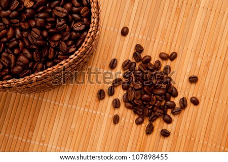 Close up of seeds in front of a basket full of coffee seeds