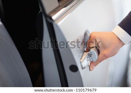 Man opening a car door in a garage
