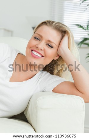 Woman lying on a sofa with a hand in her hair in a living room