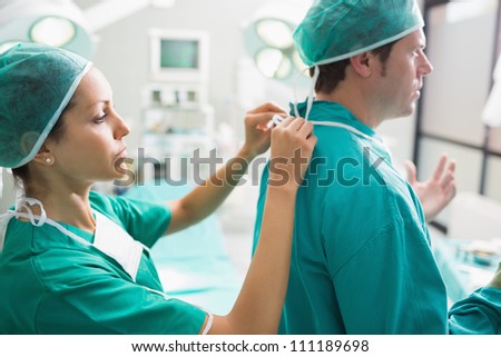 Nurse helping a surgeon in an operating theater