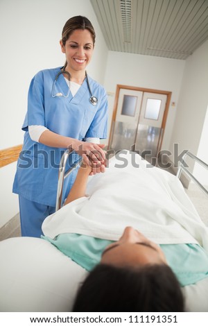 Nurse holding hand of a female patient in hospital corridor