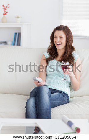 Smiling woman holding a glass of wine in a living room