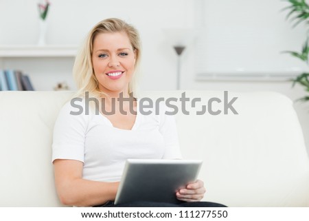 Casual woman sitting on a sofa using an book in a lounge