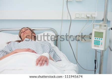 Woman sleeping on a medical bed in hospital ward