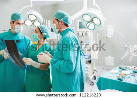 Medical team speaking of a X-ray in an operating theatre