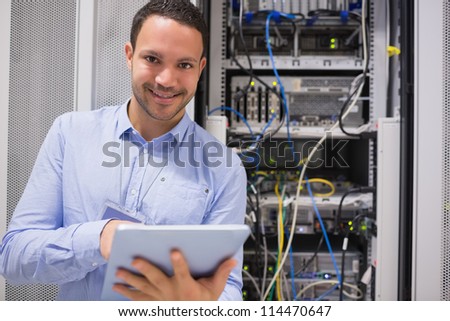 Happy worker with tablet pc in data centre