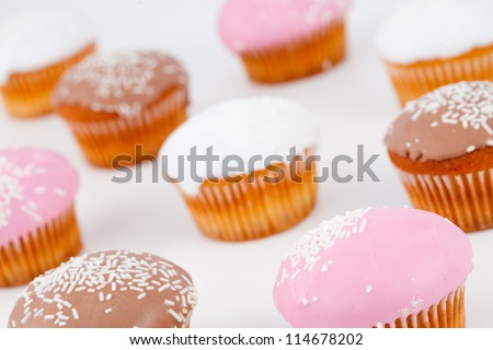 Blurred muffins with icing sugar against a white background