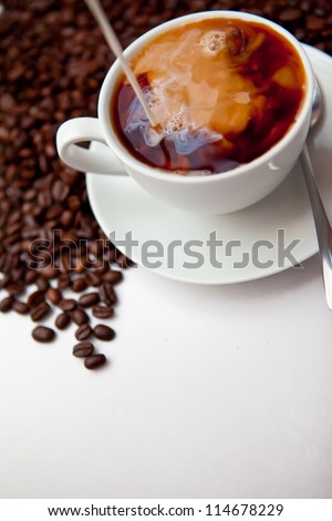 Black coffee and milk  with beans against a white background