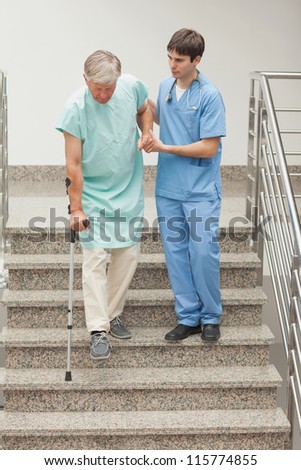 Male nurse assisting a patient on stairs in hospital