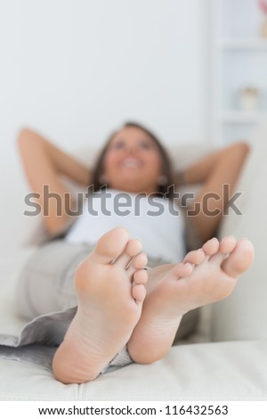 Woman relaxing at home with her feet up on the sofa