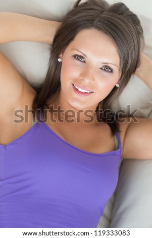 Cheerful woman lying on the sofa in the living room