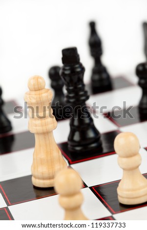 White queen and black king standing at the chessboard facing each other