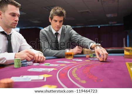 Man placing bet im poker game at casino