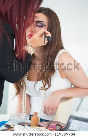 makeup artist applying make up on woman\'s eyes