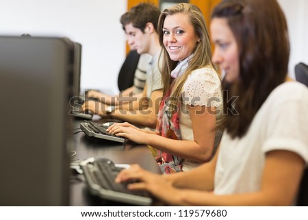 Students sitting at the computer while smiling in computer class